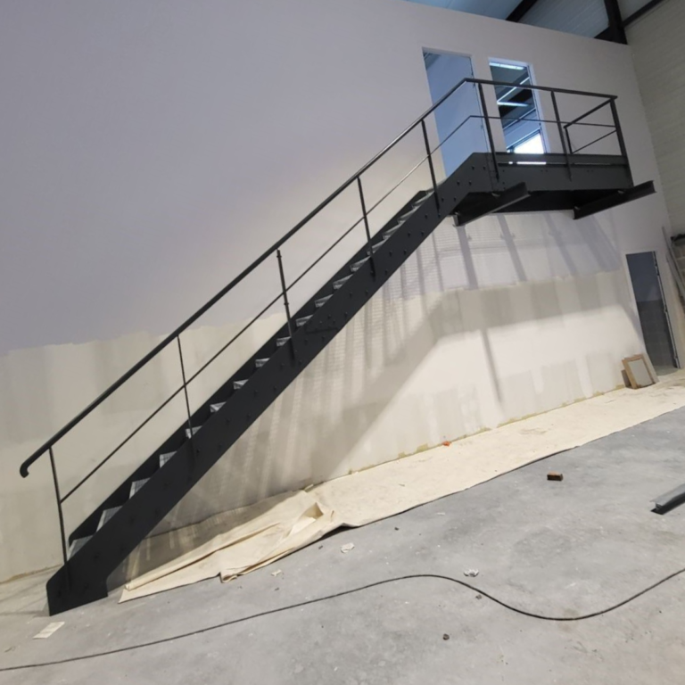 escalier industriel droit noir avec palier sur un mur blanc